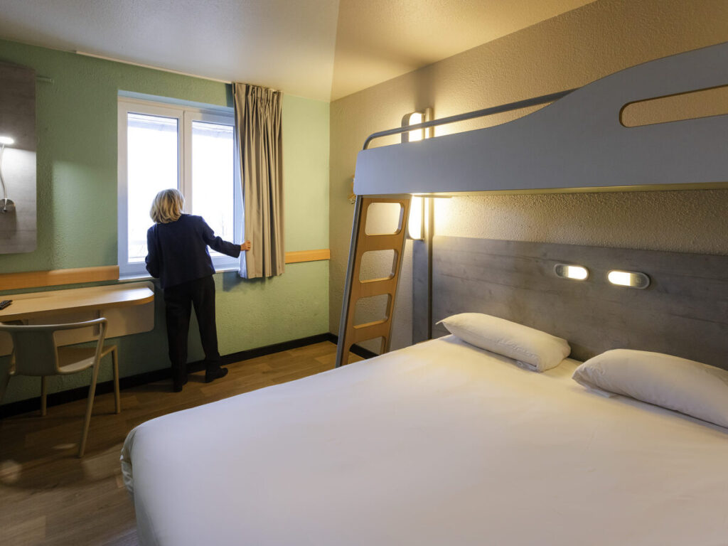 Vue sur la chambre d'hôtel, lit au draps blanc